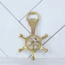 Solid brass ship's wheel bottle opener with a shiny finish, shown from a top-down view.