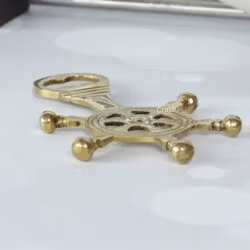 Angled view of the brass nautical helm bottle opener, highlighting its 3D design and sturdy construction.