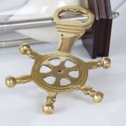 Side profile of the ship's wheel bottle opener, showing the thickness of the brass and the opener mechanism.