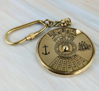 Solid brass 100-year perpetual calendar keychain with nautical anchor and ship engravings and a secure carabiner clip.