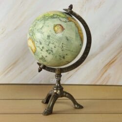 Antique world globe with a vintage map on a decorative brass tripod stand, perfect for desk or office decor.