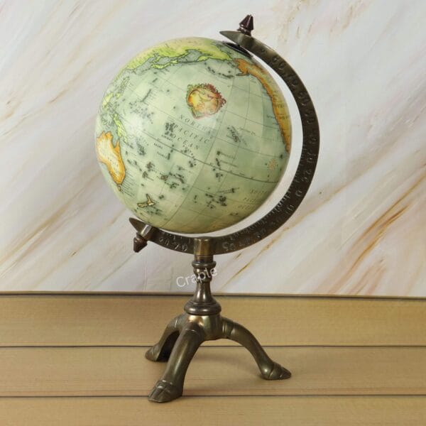 Antique world globe with a vintage map on a decorative brass tripod stand, perfect for desk or office decor.