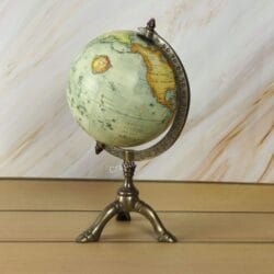 Low-angle view of the vintage-style decorative desk globe on its elegant brass tripod base.
