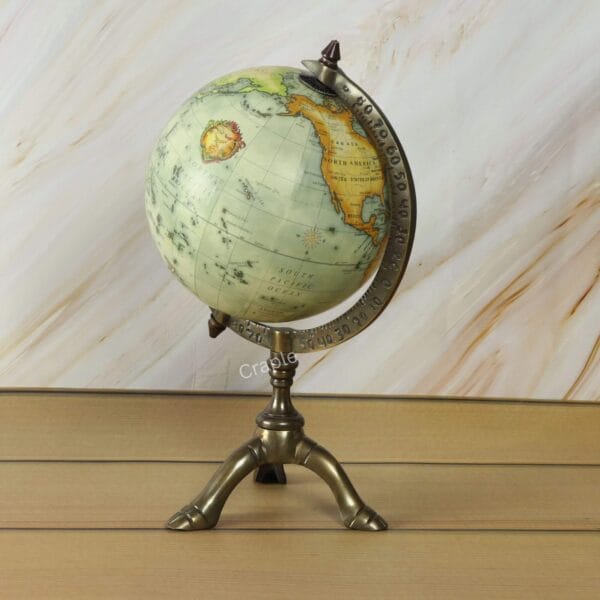 Low-angle view of the vintage-style decorative desk globe on its elegant brass tripod base.