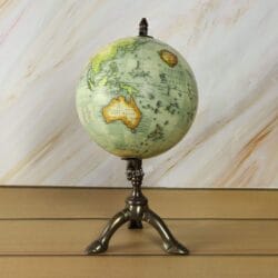 The decorative world globe showing a detailed map of North and South America on its brass stand.