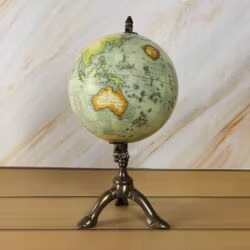 The decorative world globe showing a detailed map of North and South America on its brass stand.