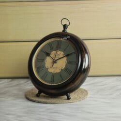 Three-quarter view of the vintage-style round wooden clock, highlighting its antique finish and classic dial design.