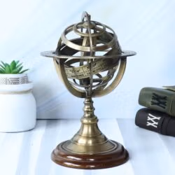 Antique brass armillary sphere on a wooden base, displayed as a decorative piece in a study.