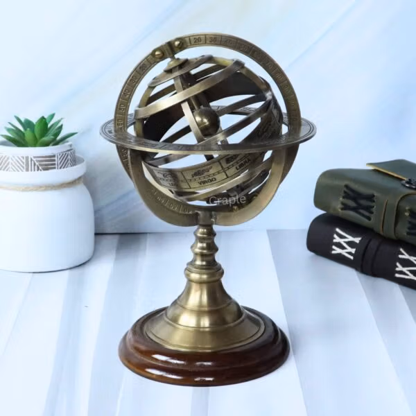 Front view of a brass celestial armillary sphere with an antique finish, sitting on a polished wood stand.