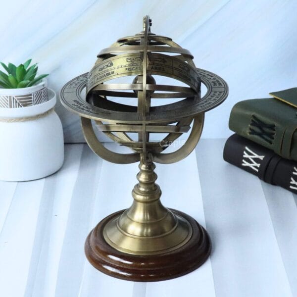 Left-angled view of the tabletop brass armillary globe, showing the engraved rings and wood base.