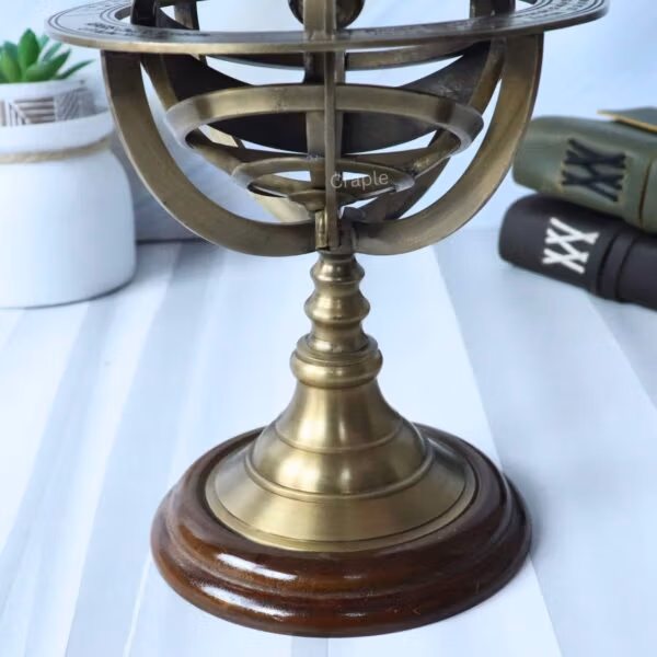 Close-up shot of the polished solid wood base and turned brass pedestal of the armillary sphere.