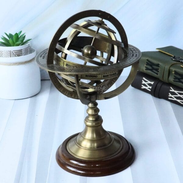 The brass and wood armillary sphere shown as a desktop accessory next to antique-style books.
