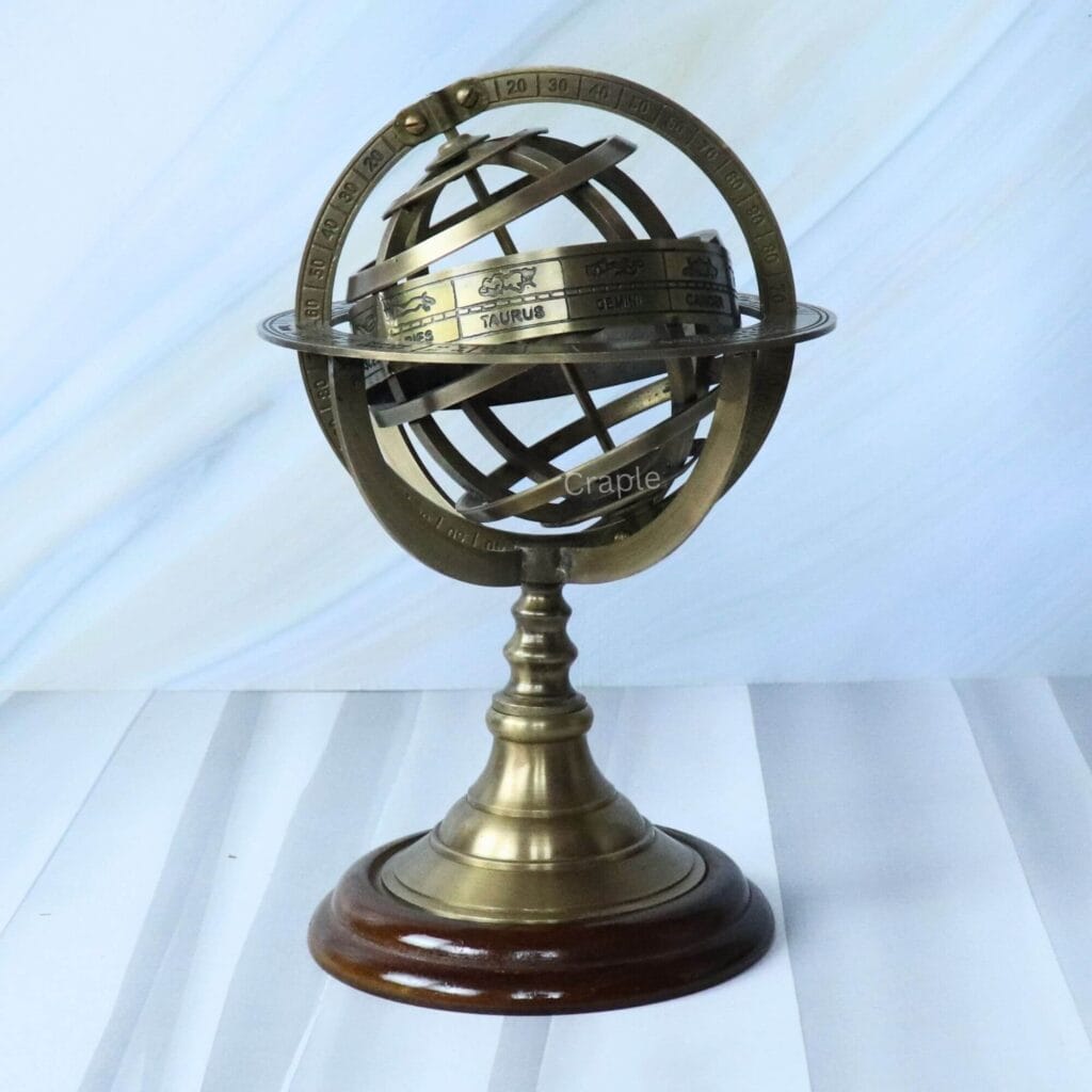 Brass celestial armillary sphere with an antique finish and engraved zodiac rings, on a polished wood base.