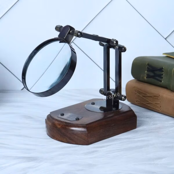 Adjustable black antique desk magnifier positioned over a book, demonstrating its use for reading and detailed work.