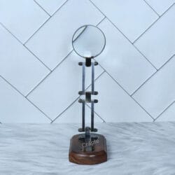 The vintage desk magnifier fully extended to its maximum height, standing on its polished wood base.