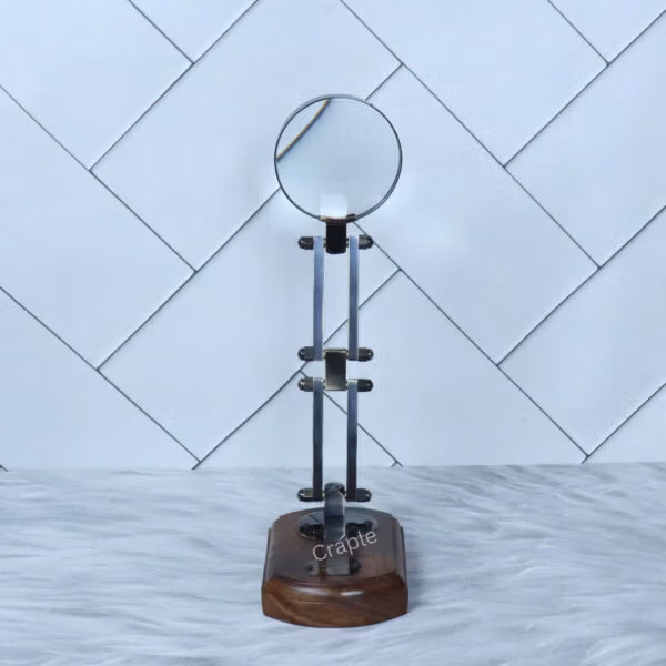 The vintage desk magnifier fully extended to its maximum height, standing on its polished wood base.
