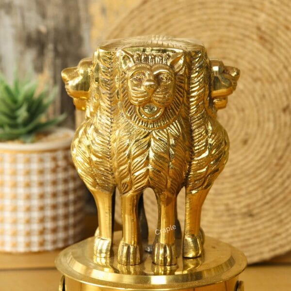 Detailed close-up of the Lion Capital of Ashoka brass statue, showing the intricate carving of the lions' faces and manes.