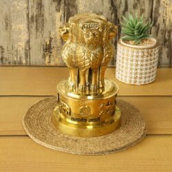 Angled side view of the brass Ashok Stambh showpiece, highlighting its polished finish and three-dimensional form.