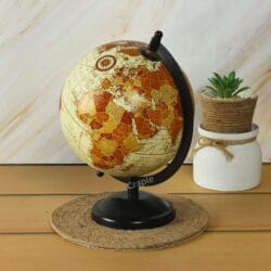 Angled side-view of the decorative world globe on its brass stand, highlighting the Americas.