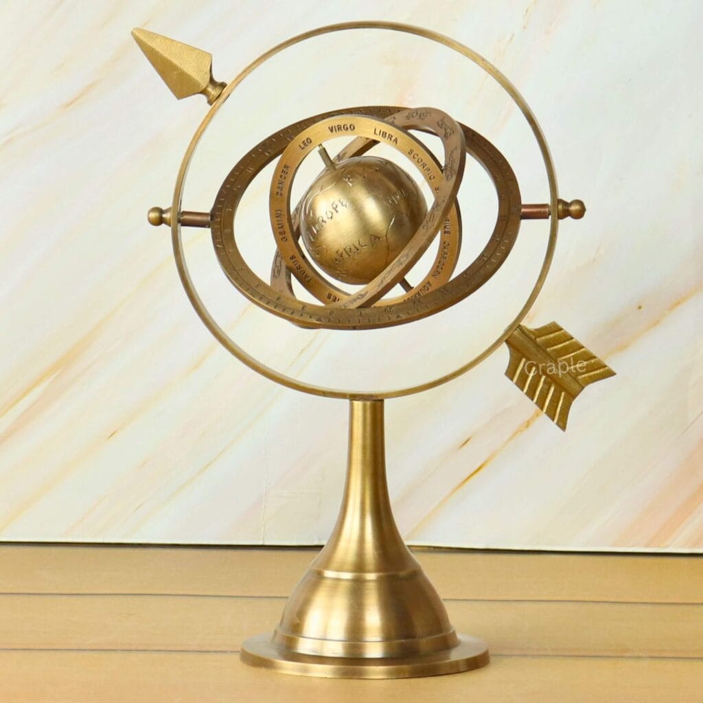 Antique brass armillary sphere with a celestial globe and interlocking rings on a solid stand, for desktop decor.
