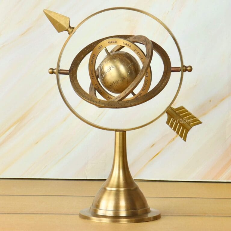Antique brass armillary sphere with a celestial globe and interlocking rings on a solid stand, for desktop decor.