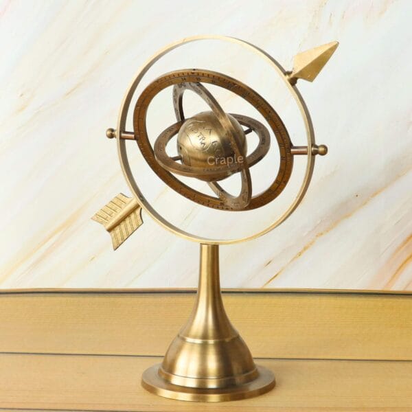 Angled view of the decorative brass celestial armillary sphere, showing the zodiac rings and central globe.