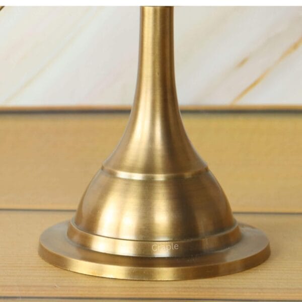 Close-up of the heavy, solid brass stand supporting the celestial armillary sphere decor.