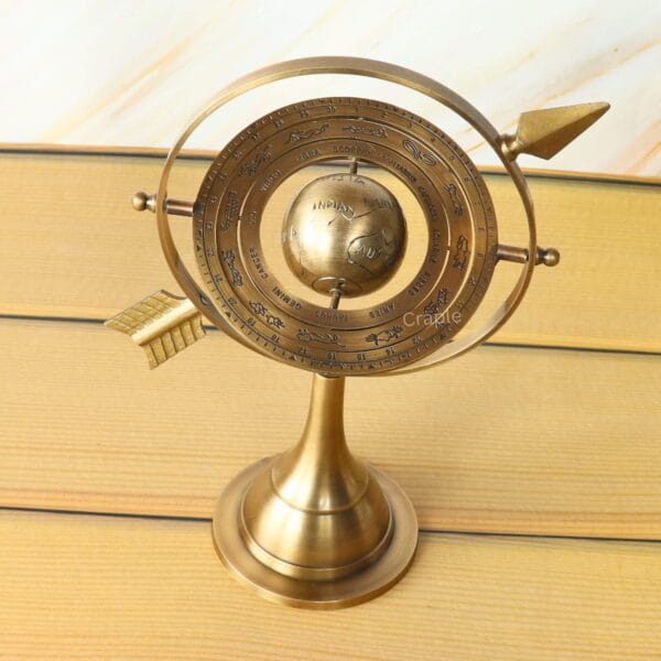 Side view of the antique brass armillary globe, highlighting the detailed engraving on the celestial rings.