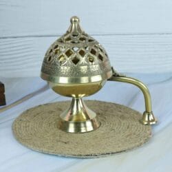 Handcrafted brass Loban Dani incense burner with an ornate cutout lid and a long handle, shown closed.