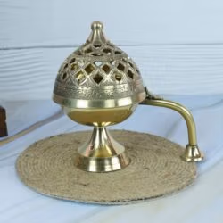 Handcrafted brass Loban Dani incense burner with an ornate cutout lid and a long handle, shown closed.