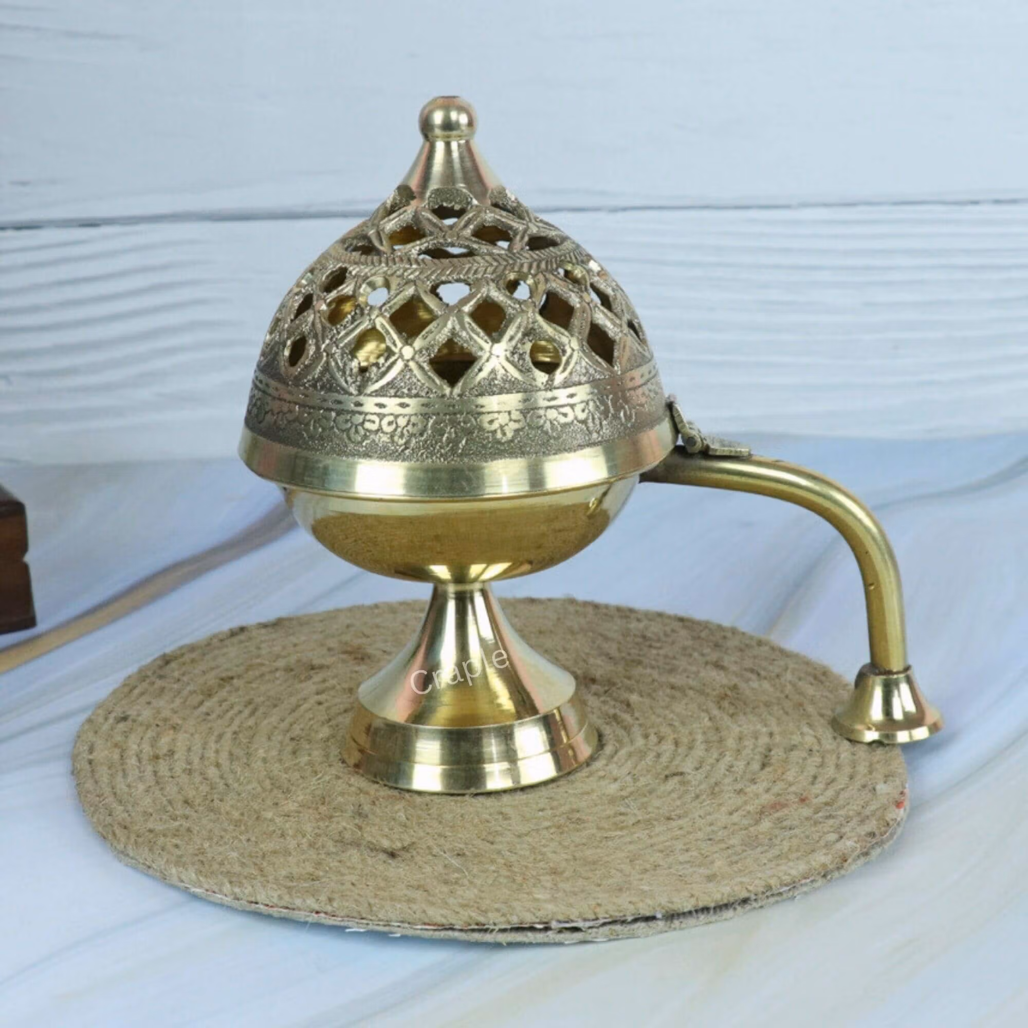 Handcrafted brass Loban Dani incense burner with an ornate cutout lid and a long handle, shown closed.