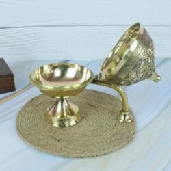 Brass incense burner (loban dani) with its ornate, hinged lid open to reveal the inner charcoal bowl.