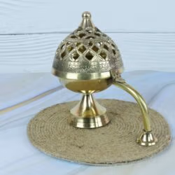 Side profile of the traditional brass incense censer, highlighting the elegant handle and pedestal base.