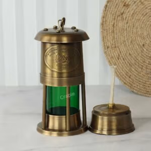 Brass nautical oil lamp with its oil burner and wick removed to display its functional parts.