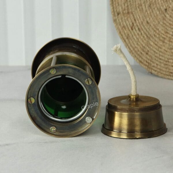 Brass Nautical Oil Lamp-5 Top-down view into the green cylinder of the brass lantern, with the oil burner and wick component resting alongside.
