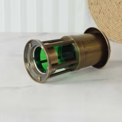 Assembled antique brass miner's lamp lying on its side, showing the detail of its base.