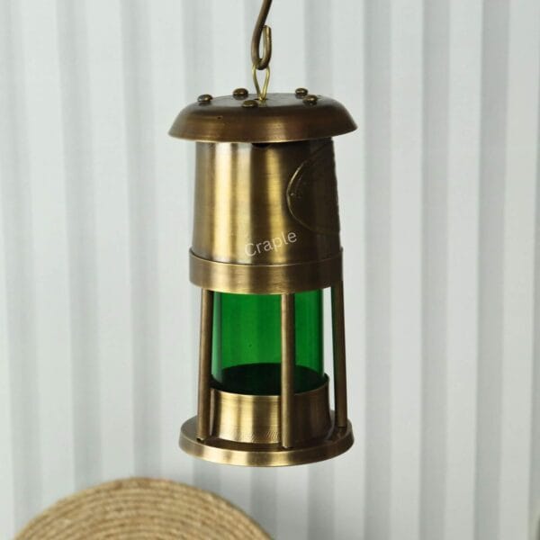 Brass Nautical Oil Lamp-9 The brass nautical oil lantern hanging from its top hook, showcasing its use as a hanging light fixture.