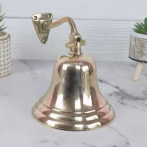 Wall-mounted solid brass nautical ship's bell with a shiny finish, complete with a traditional rope pull.