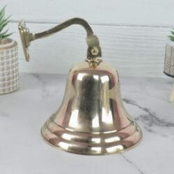Side view of the shiny brass wall-mounted nautical bell, showing the elegant curve of the mounting bracket.