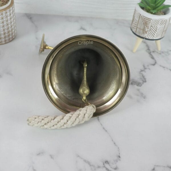 Brass Nautical Ship Bell-3 Top-down view looking into the brass ship's bell, showing the internal clapper and hand-knotted cotton lanyard.