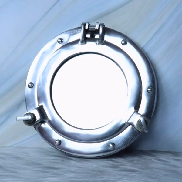 Front view of the round nautical porthole mirror in a closed position, showing the reflective glass.