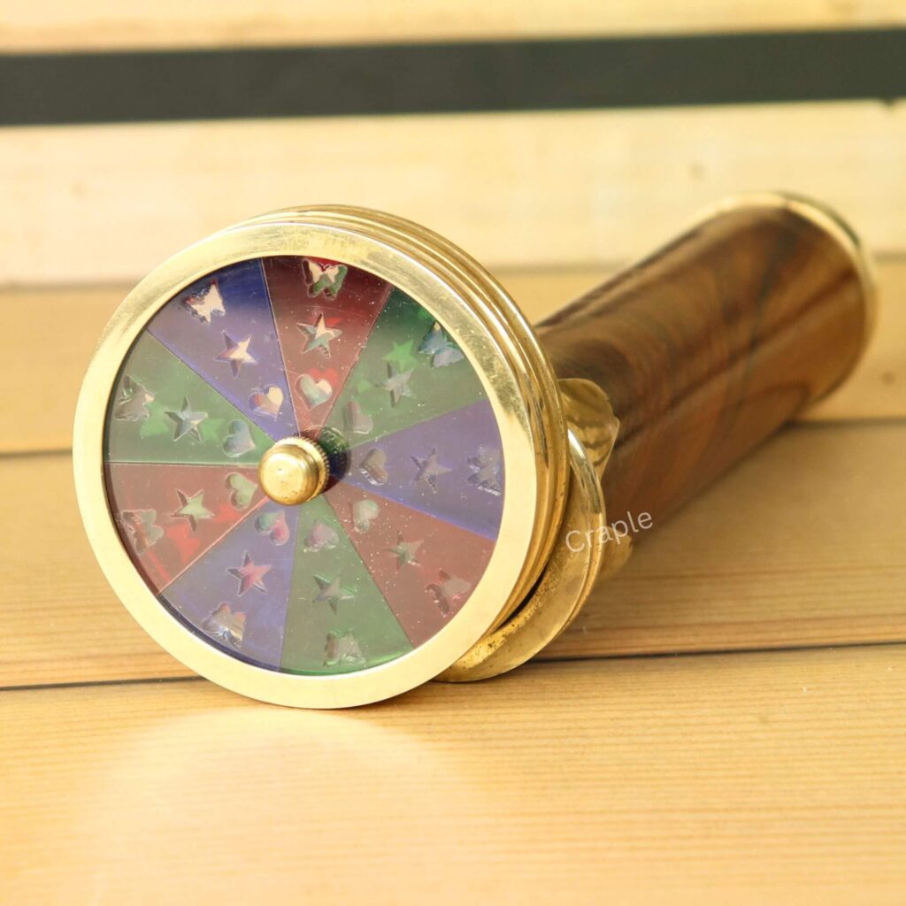 A close-up of the colorful 3D pattern wheel on the wooden and brass kaleidoscope.