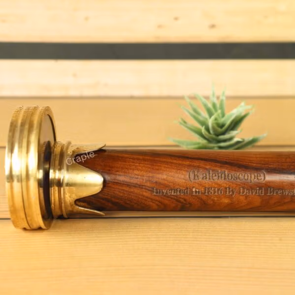 Detailed close-up on the polished wooden body and brass fittings of the classic optical kaleidoscope.