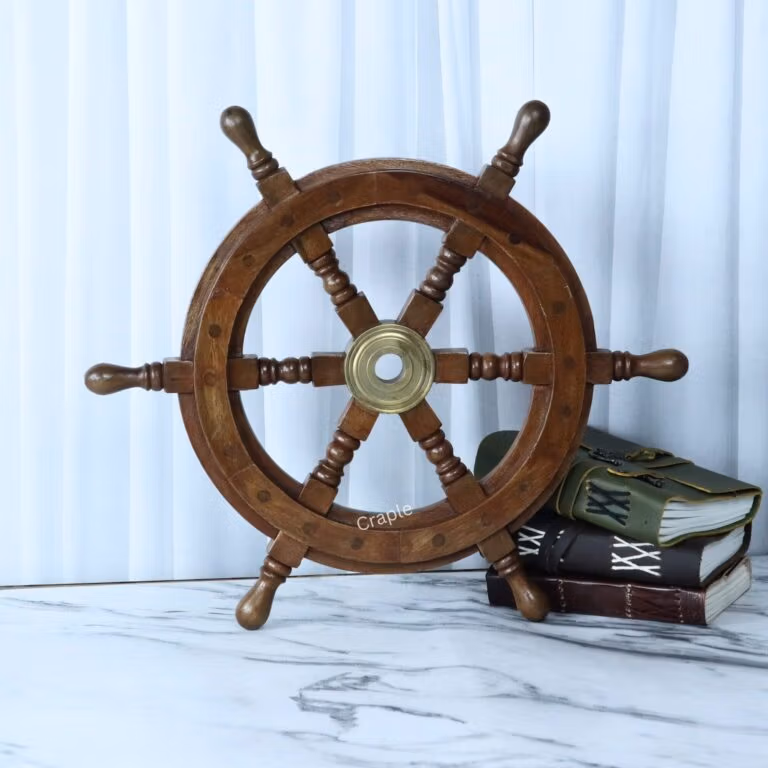 Decorative wooden ship wheel with 6 spokes and a polished brass center hub, leaning against a white background.