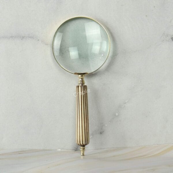 Top-down view of the 5X magnifier lens, showing its clarity and the shiny brass frame.