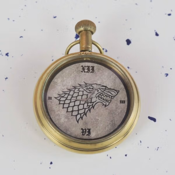 Close-up of the Game of Thrones pocket watch dial, showing the detailed Direwolf sigil and Roman numerals.