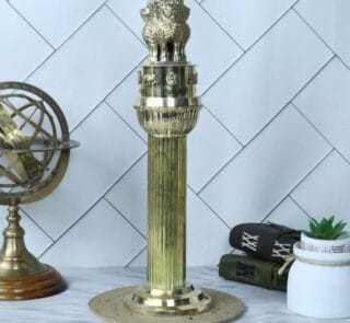 Grand tall brass Ashoka Pillar sculpture displayed on a desk as a piece of heritage decor.