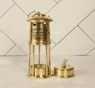 Handcrafted antique brass miner's lantern with a shiny finish, shown with its removable oil burner base.