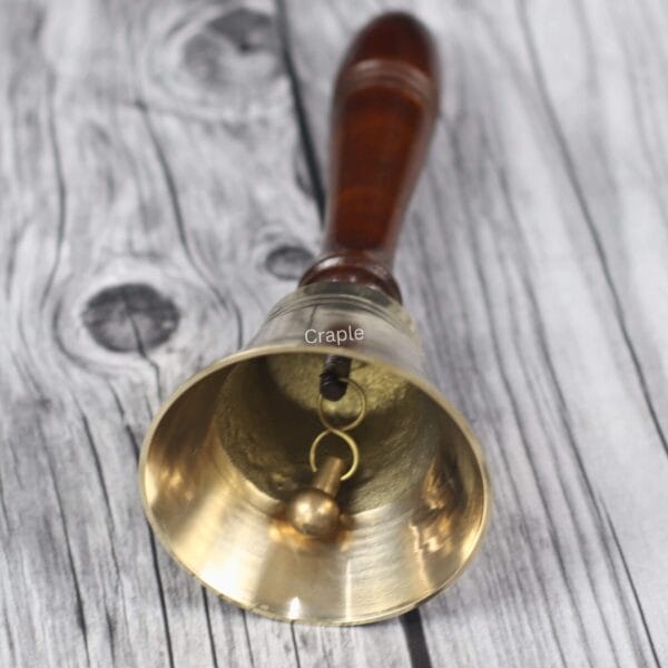 Close-up view inside the golden brass bell, showing the metal clapper that creates a clear, loud ring.