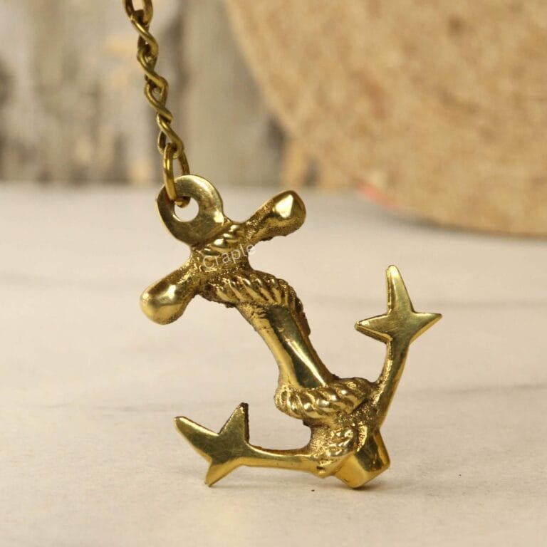 A dynamic angled view of the handmade brass anchor keychain, highlighting its shiny finish and three-dimensional rope detail.